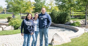 Parents and their BYU-Idaho student stand in the quad in front of the Taylor building.