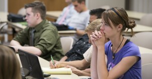 A female student listens intently during a public policy history class
