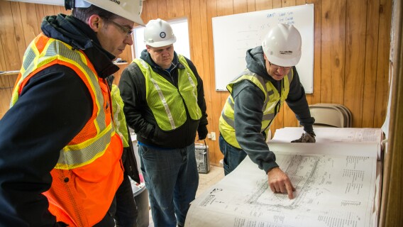A professor and his students view a construction project during a civil engineering tour.
