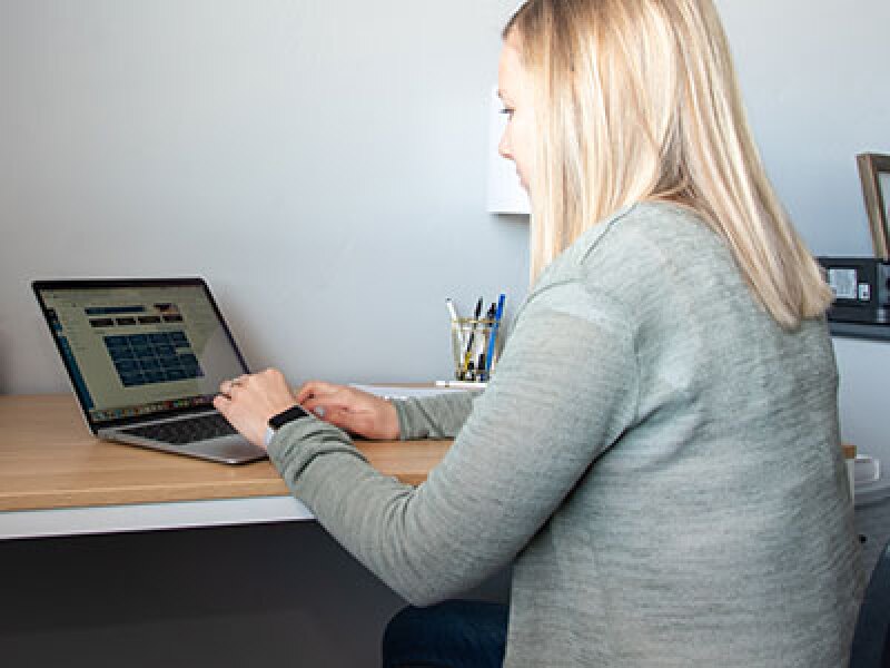 Student types on a computer at a desk.