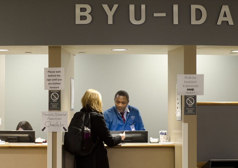 A student checking in at the front desks of the Student Health Center