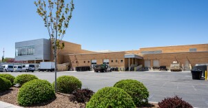 A side view of the Manwaring Center where delivery trucks are parked at loading docks.