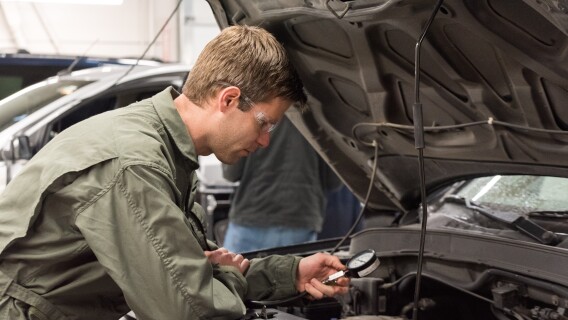 A student works on an engine in the Advanced Vehicle Systems Lab 3.